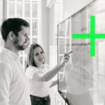 Two colleagues are talking at a flipchart