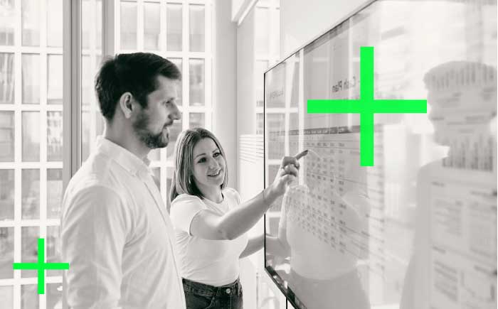 Two colleagues are talking at a flipchart