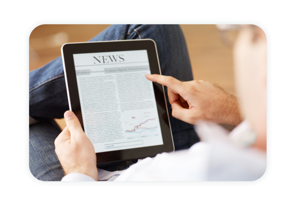 A person looking at the newspaper on their tablet